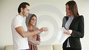 Young happy couple getting keys from new house