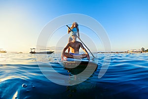 Young happy couple have fun on stand up paddleboard