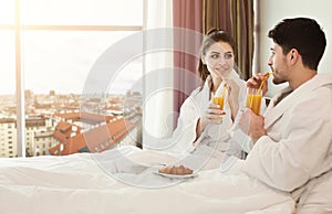 Young happy couple having breakfast in bed