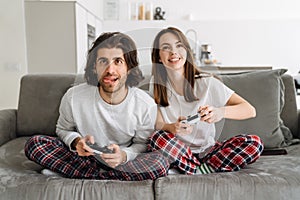 Young happy couple holding credit card and joystick