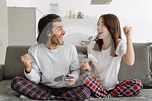 Young happy couple holding credit card and joystick