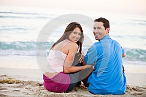 Young happy couple holding hands on beach