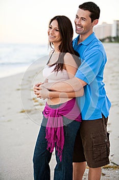 Young happy couple holding hands on beach