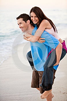 Young happy couple holding hands on beach