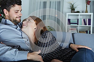 Young happy couple hug on sofa