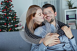 Young happy couple hug on sofa