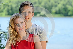 Young happy couple hugging and laughing on river background