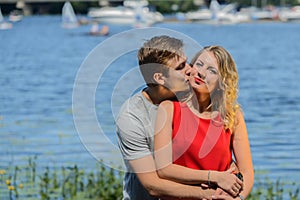 Young happy couple hugging and laughing on river background