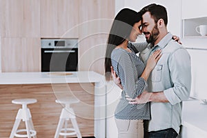 Young Happy Couple Hugging in Modern Kitchen.