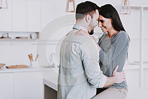 Young Happy Couple Hugging in Modern Kitchen.