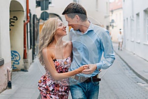 Young happy couple hugging while walking on the street.