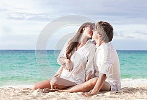 Young happy couple kissing at tropical beach. honeymoon