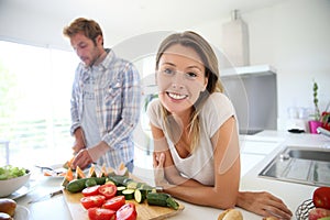 Young happy couple in the kitchen preparing meal