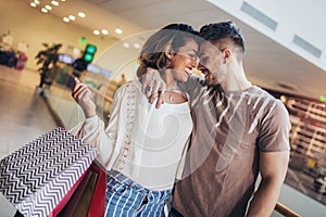 Young happy couple looking each other after shopping