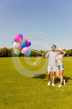 Young happy couple in love embracing and holding balloons