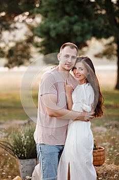 young happy couple in love hugging on nature. Man and woman hugging, sunlight in summer meadow. Happy family in the