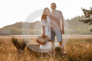 young happy couple in love hugging on nature. Man and woman hugging, sunlight in summer meadow. Happy family in the