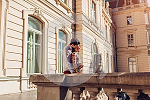 Young happy couple in love hugging outdoors. Romantic man and woman walking by old city architecture