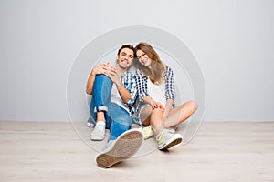 Young happy couple in love sitting on the floor