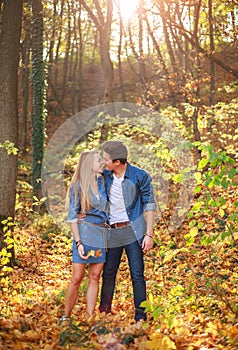 Young happy couple in love together in forest park on sunny day