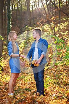 Young happy couple in love together in forest park on sunny day