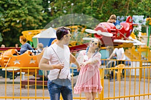 Young happy couple in love walks and has fun in an amusement park