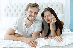 Young happy couple lying together in bed.