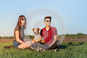 Young happy couple of man and woman with staffordshire terrier d