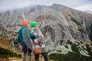 Young happy couple at mountain hike, hugging each other.