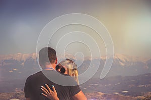 Young happy couple in mountains against sunset
