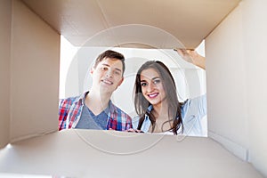 Young happy couple moving into their new home. They unpacking and cleaning new home