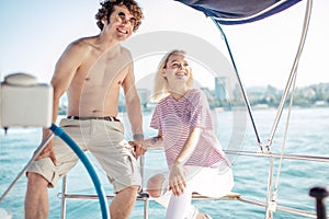 Young happy couple navigating on a yacht in caribbean sea