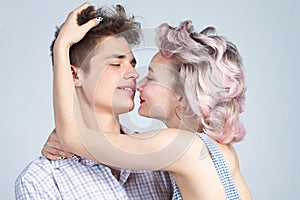 Young happy couple posing in studio.Gorgeous woman with long blond hair posing with handsome brunette man with sportive