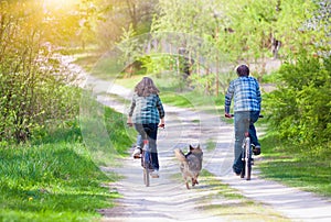 Young happy couple ride bicycles