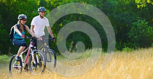 Young Happy Couple Riding Mountain Bikes Outdoor