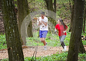 Young happy couple running with a dog