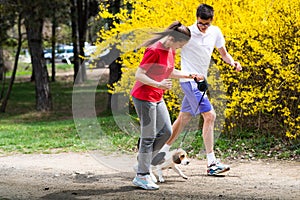 Young happy couple running with a dog