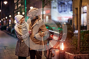 A young happy couple on the sidewalk. Relationship, together, Xmas