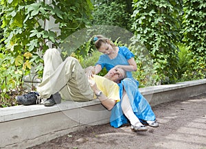 Young happy couple sits in the arbour twined greens