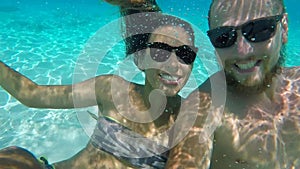 Young Happy Couple in Sunglasses Making Underwater Selfie with GoPro Camera. HD Slow Motion. Thailand.