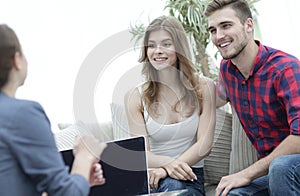 Young happy couple at therapy session with family psychologist