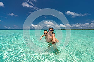 Young happy couple on tropical beach at summer vacation