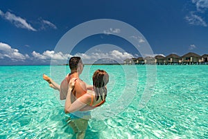 Young happy couple on tropical beach at summer vacation