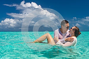 Young happy couple on tropical beach at summer vacation