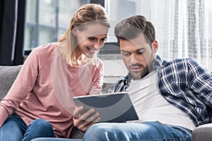 young happy couple using digital tablet