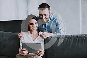 Young Happy Couple Using Tablet Device at Home.