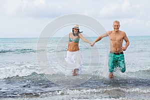 Young happy couple walking on beach sunset holiday