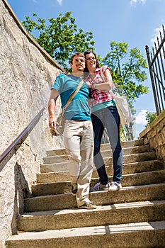 Young happy couple walking down stairs smiling