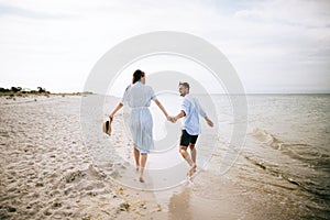 Young happy couple walking on sea beach