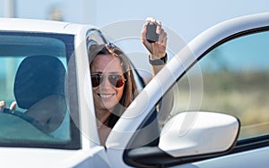 Young happy driver woman with car key in her hand